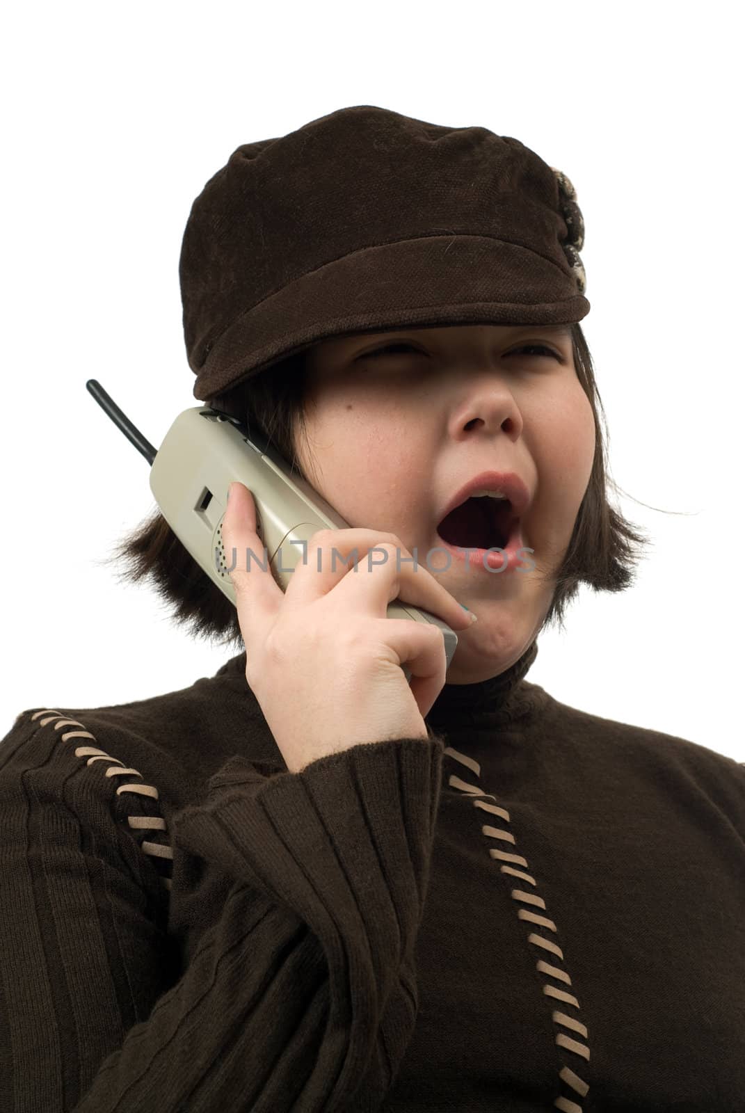 A young girl yawning at a boring conversation she is having on a cordless phone, isolated against a white background