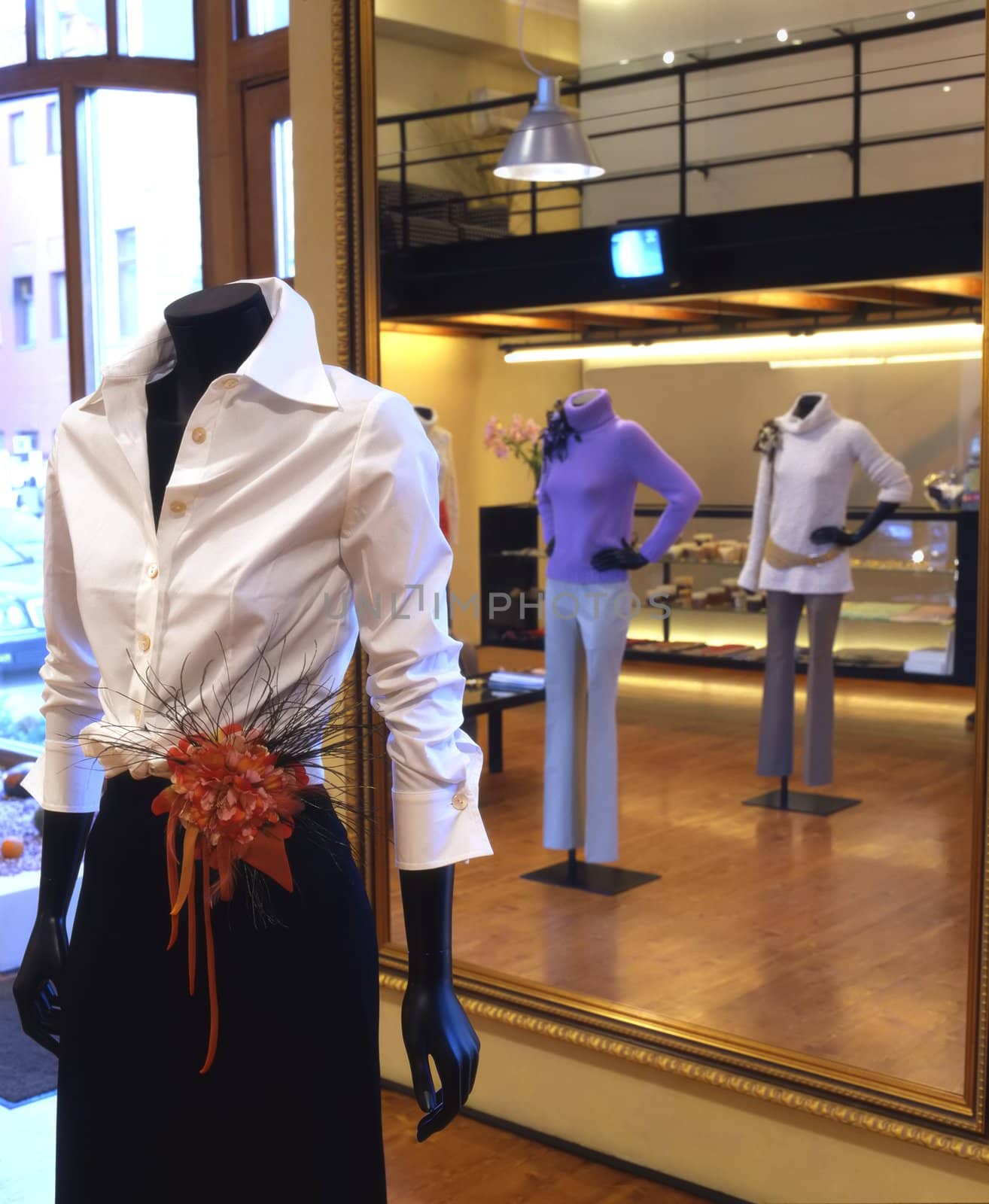 Interior of the fashionable shop with mannequin in white blouse
