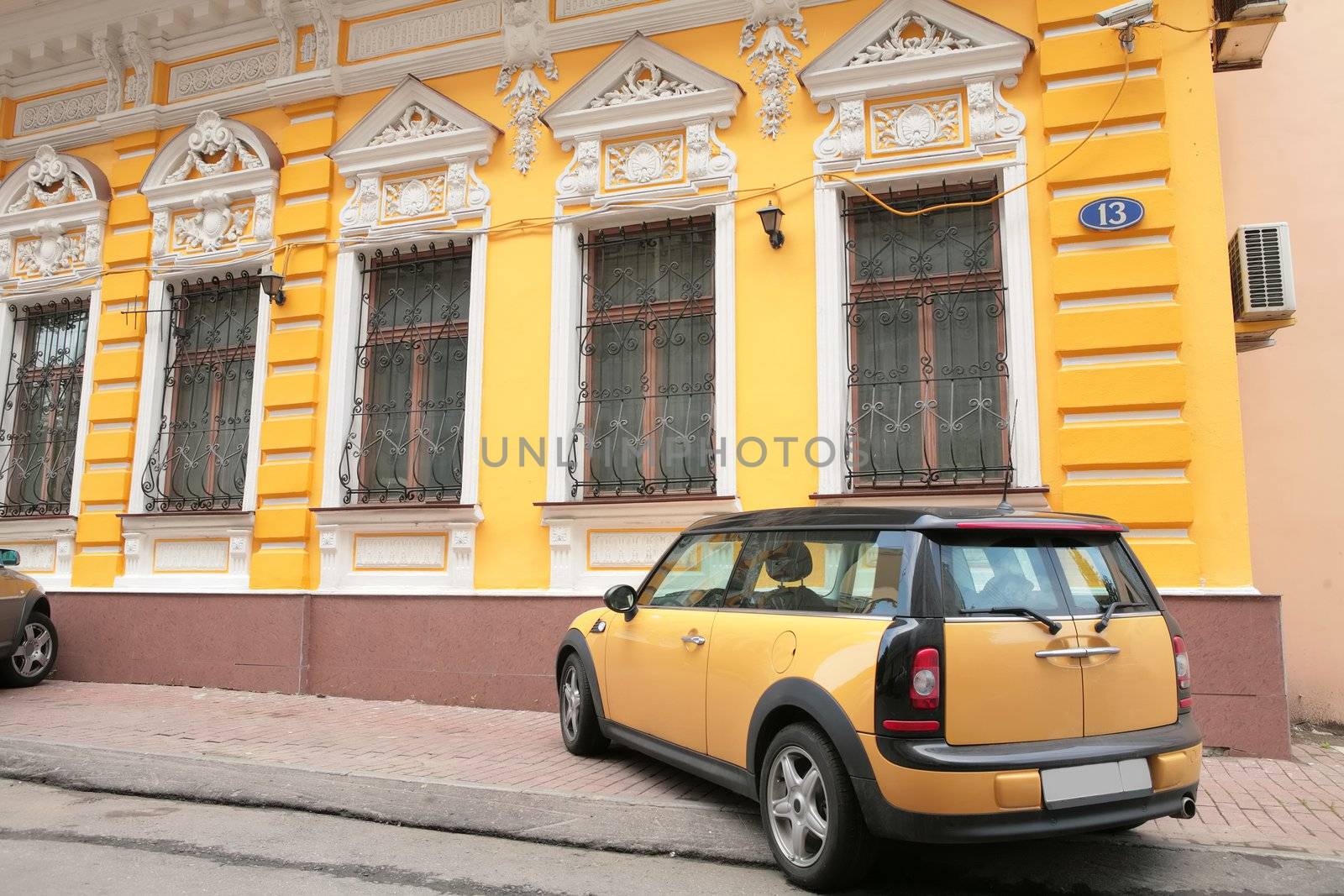 yellow car near old-time building number 13