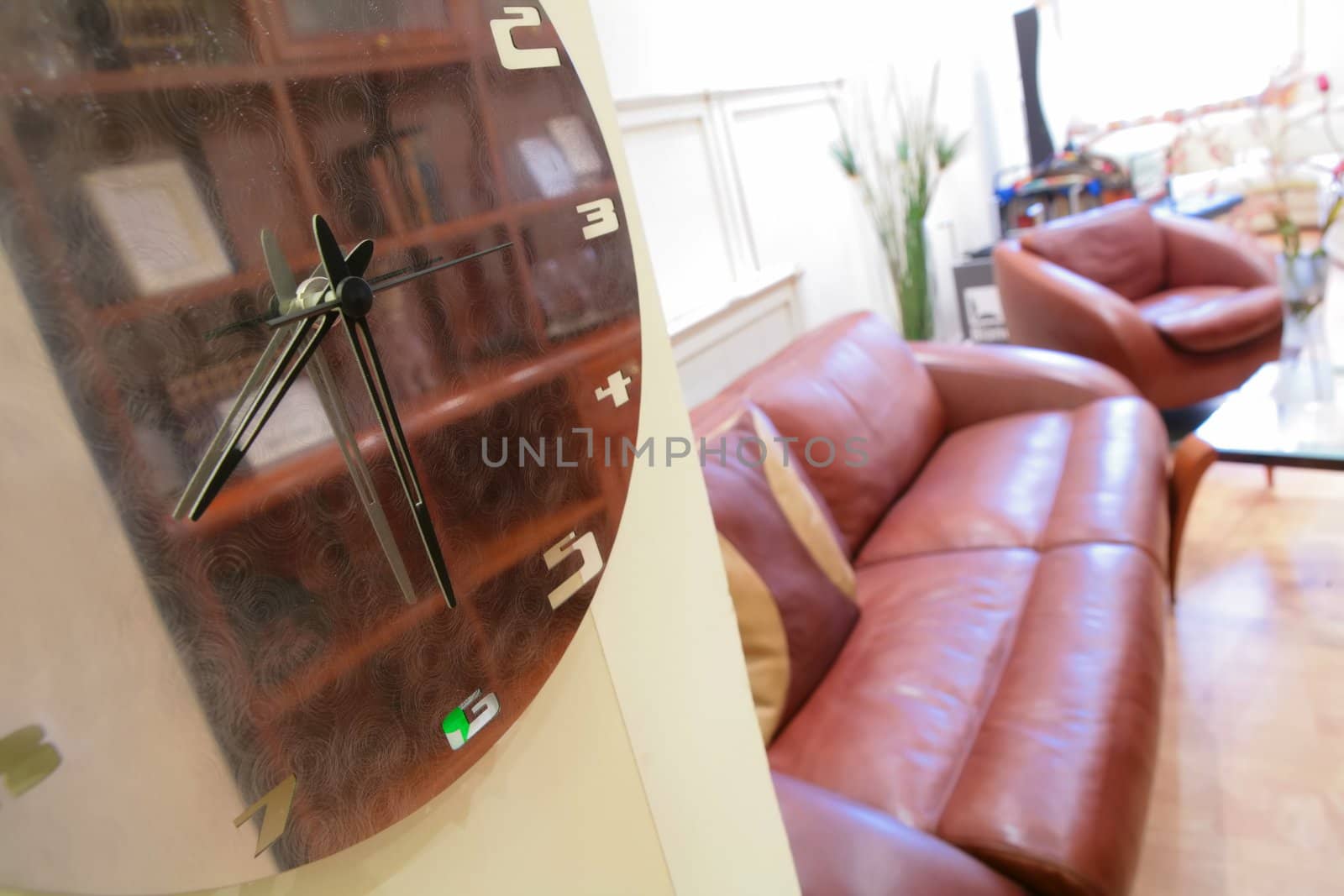 wall clock in interior of the drawing room with leather sofa