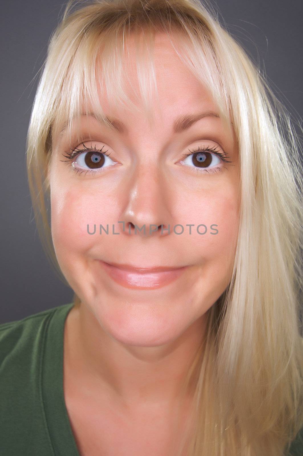 Beautiful Blond Woman with Funny Face against a Grey Background