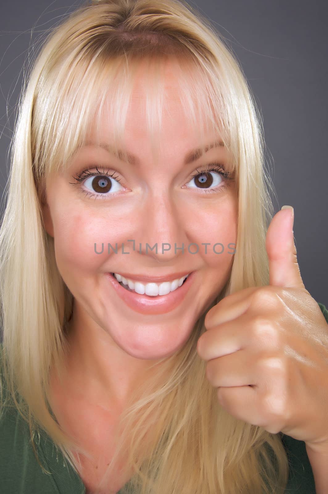 Beautiful Woman with a Thumbs Up Against a Grey Background.