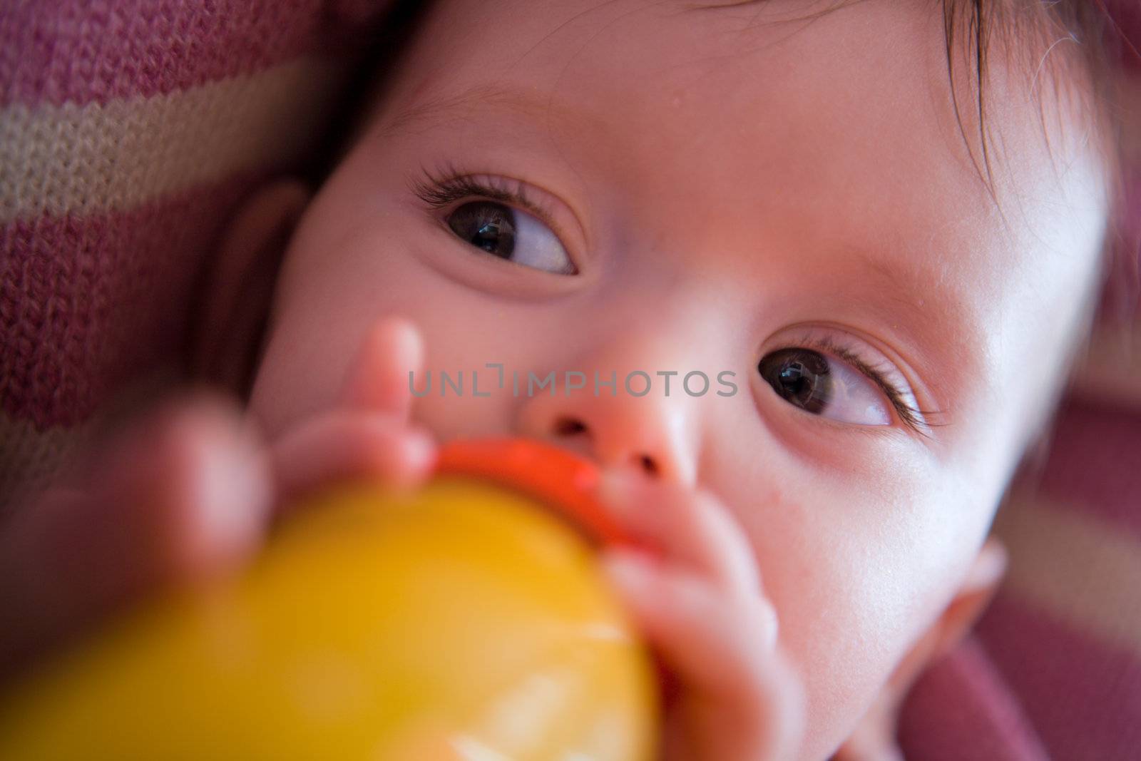 Adorable Seven month Baby eating from bottle closeup