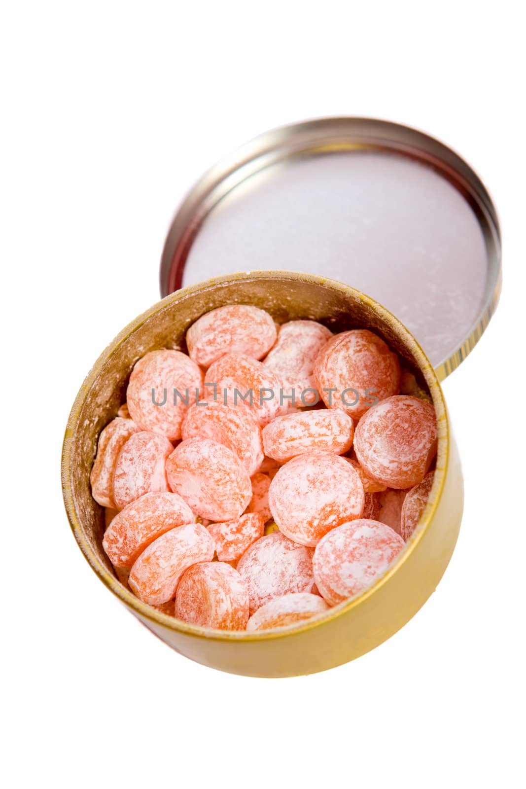 Orange candies inside tin jar 