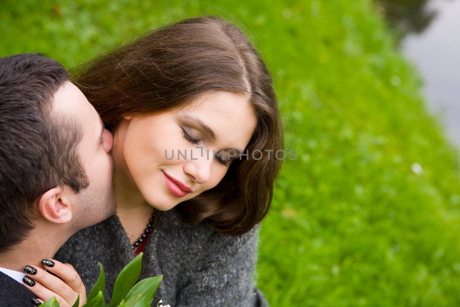 Two young lovers enjoying each other in park