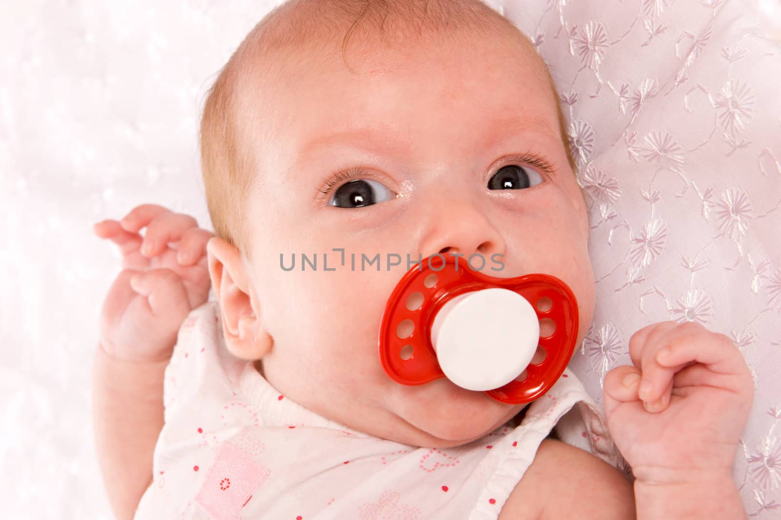 Baby girl in the age of one months with pacifier