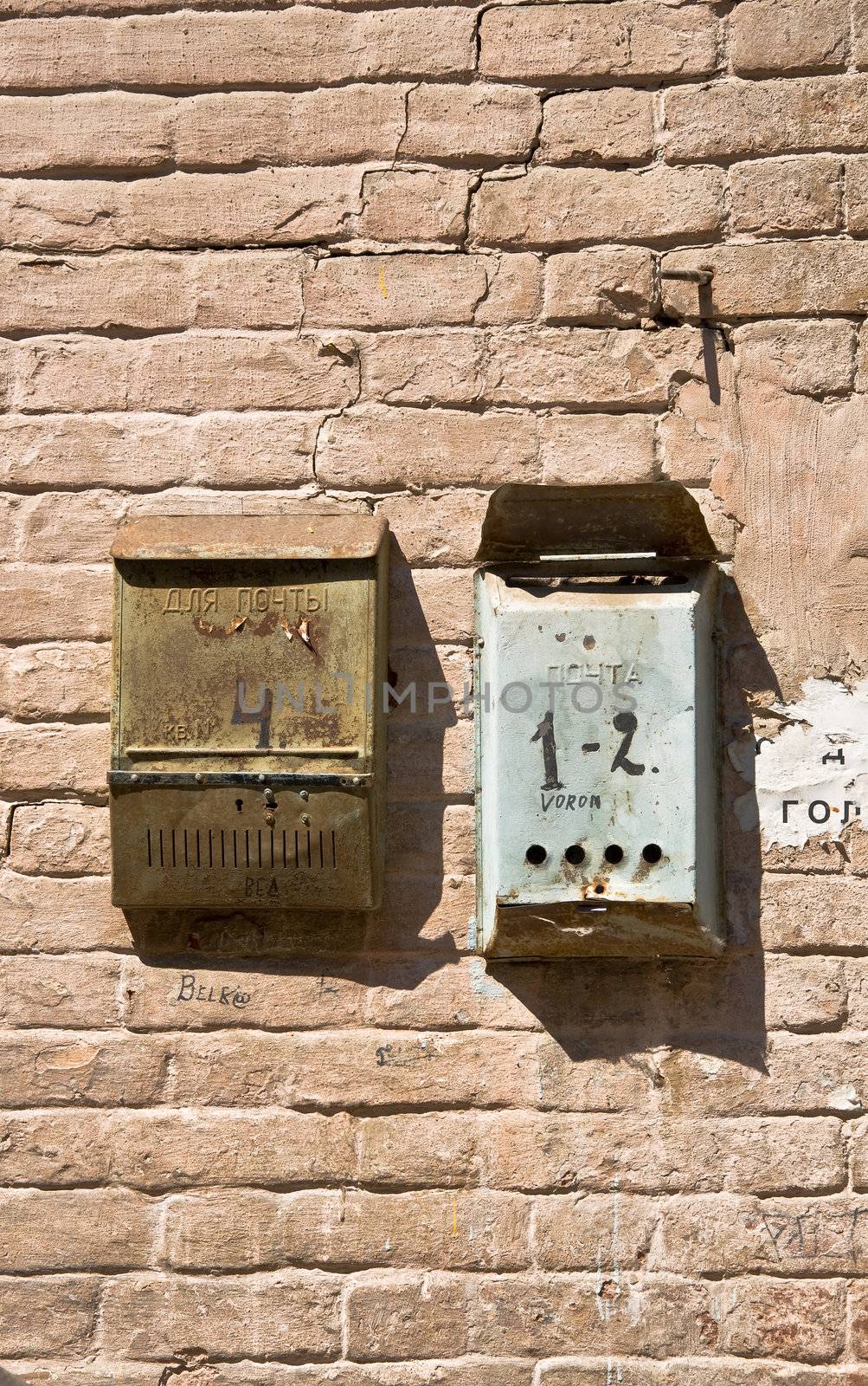 The old brick wall with mailboxes. Rusty metal and old brickwork. Close-up, fragment.