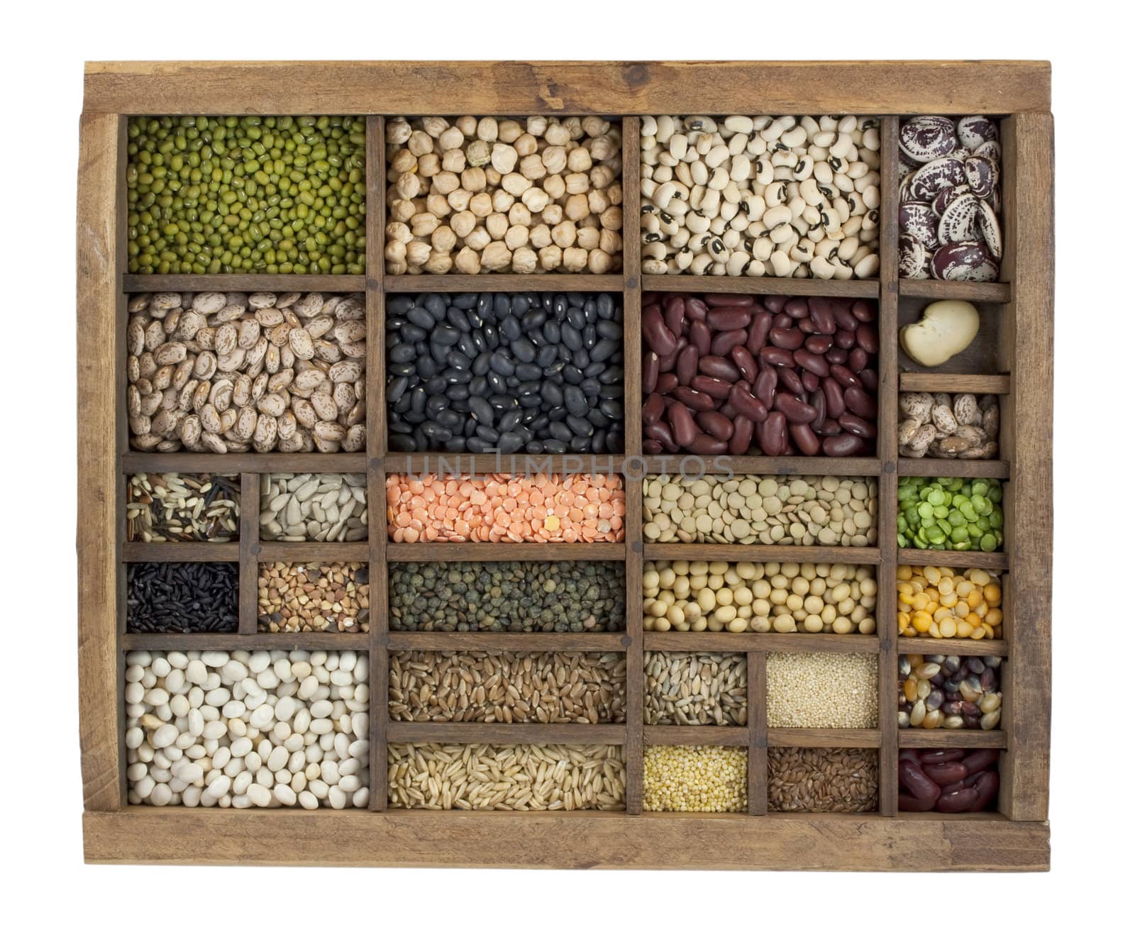 vintage, wooden typesetter case with variety of beans, lentils, peas, grains and seeds isolated with clipping path