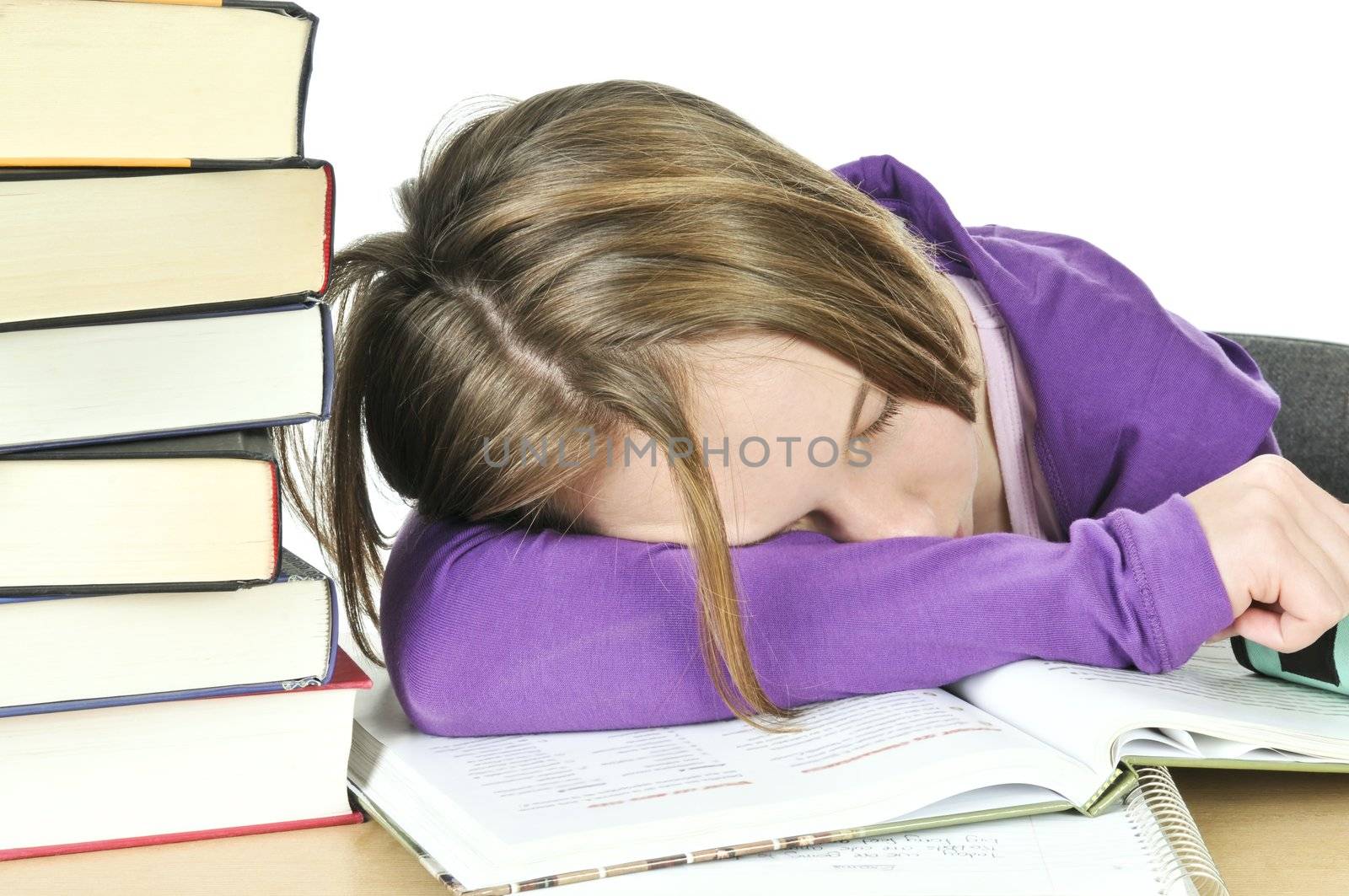 Teenage girl studying at the desk being tired