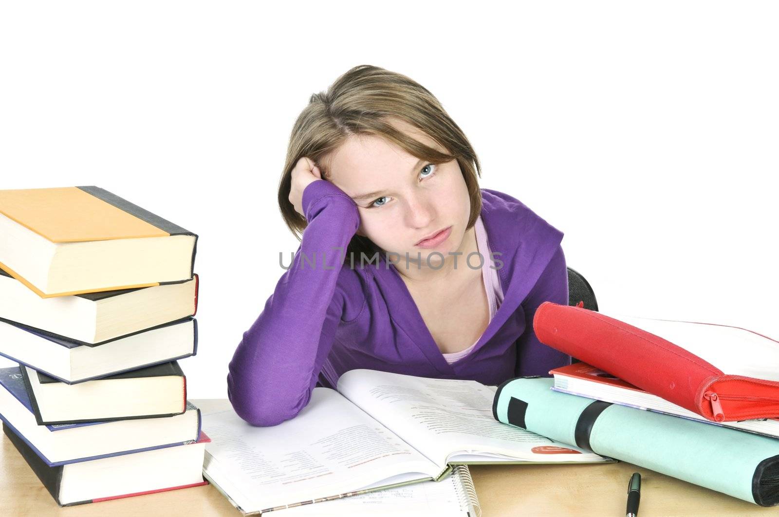 Unhappy teenage girl studying at the desk