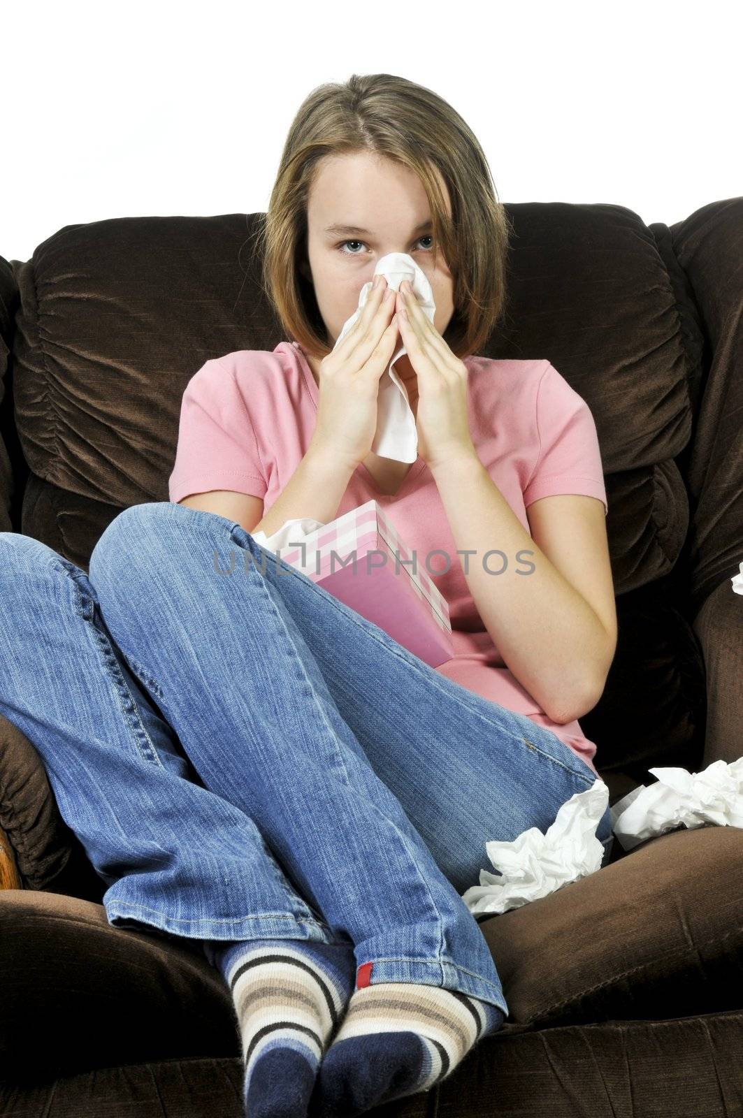 Teenage girl with a cold sitting in a chair with tissue box