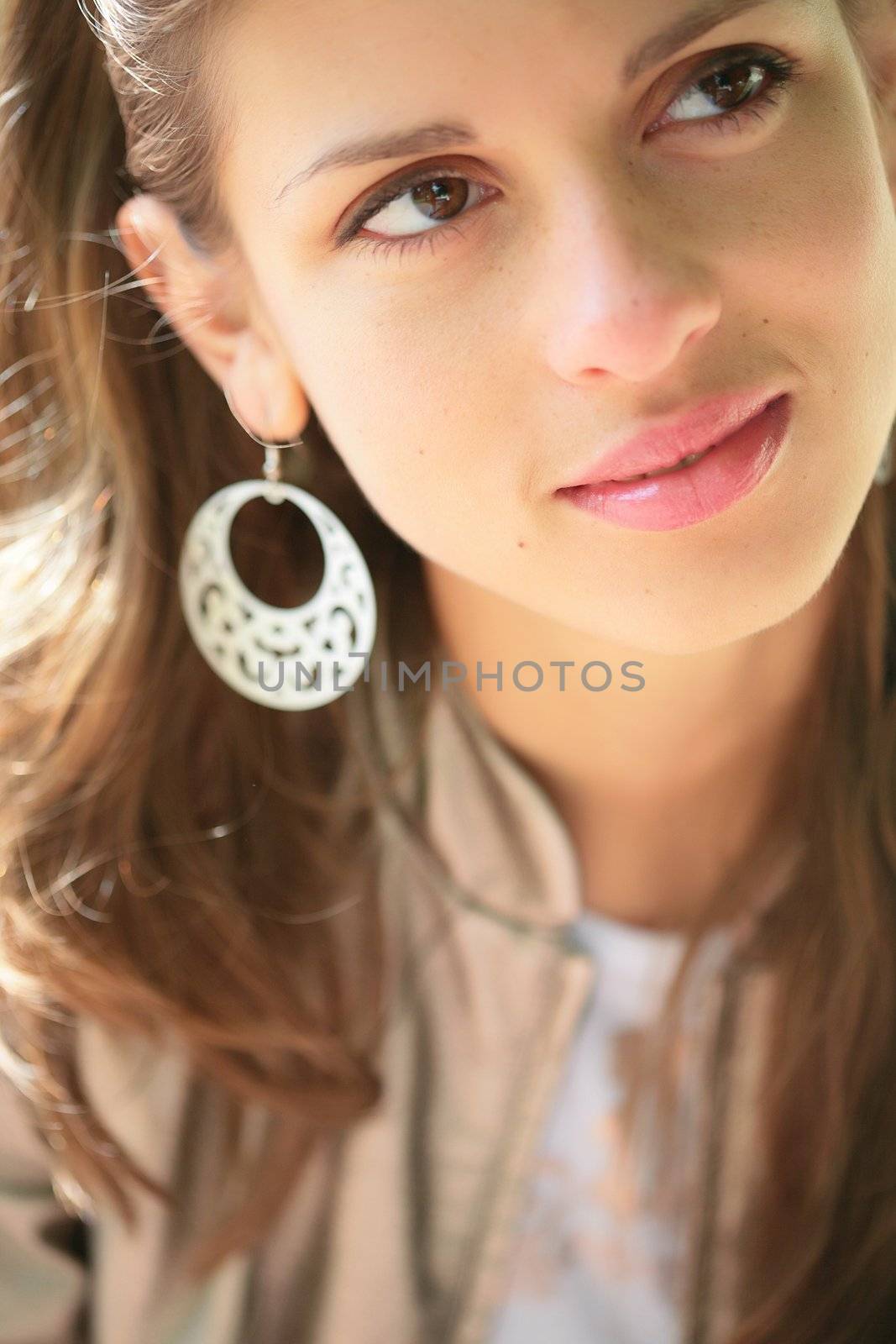 close-up portrait of the beautiful young brunette in silver earring