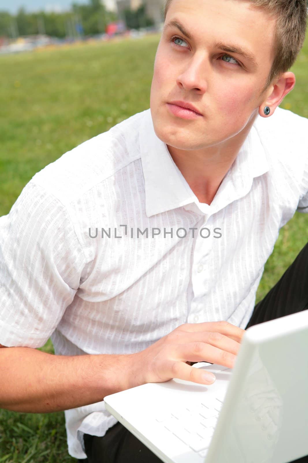 youth with green eye keeps in hand laptop
