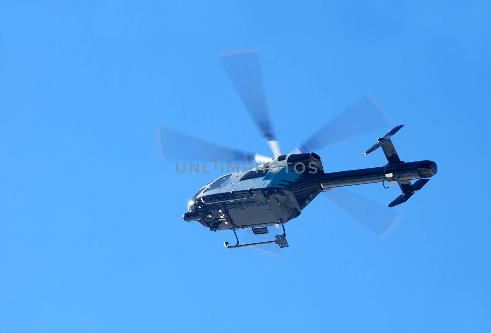 mountain rescue helicopter flying shown against blue sky