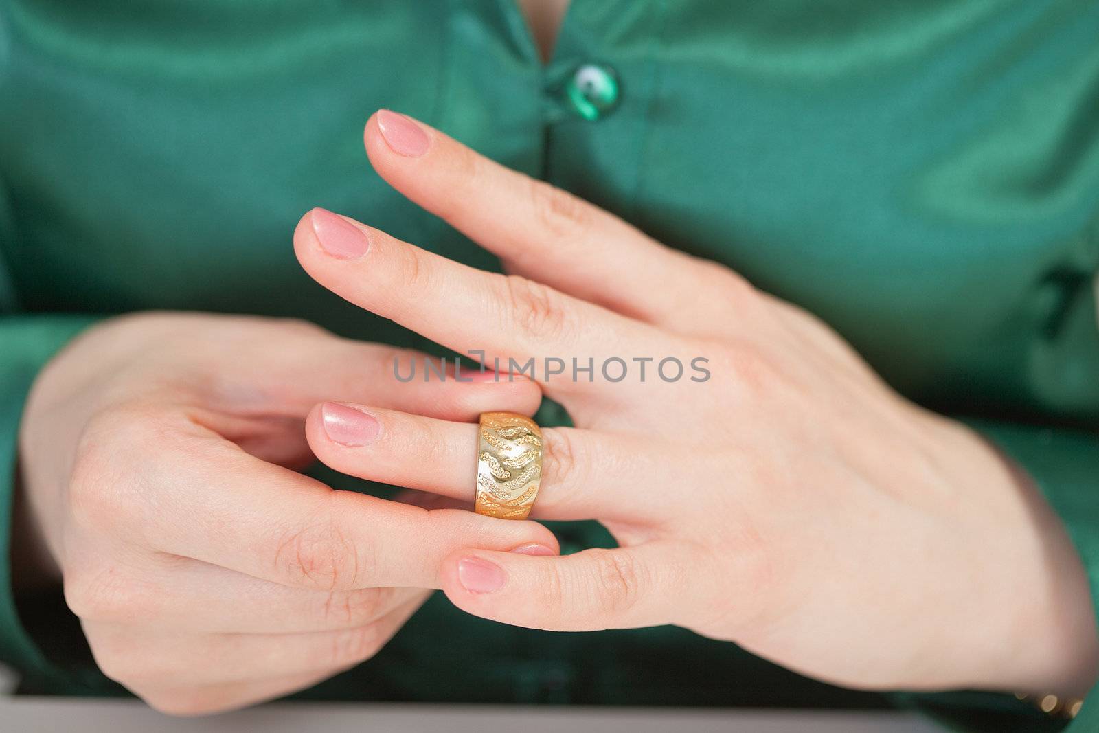 A woman tries on a large gold ring on his finger