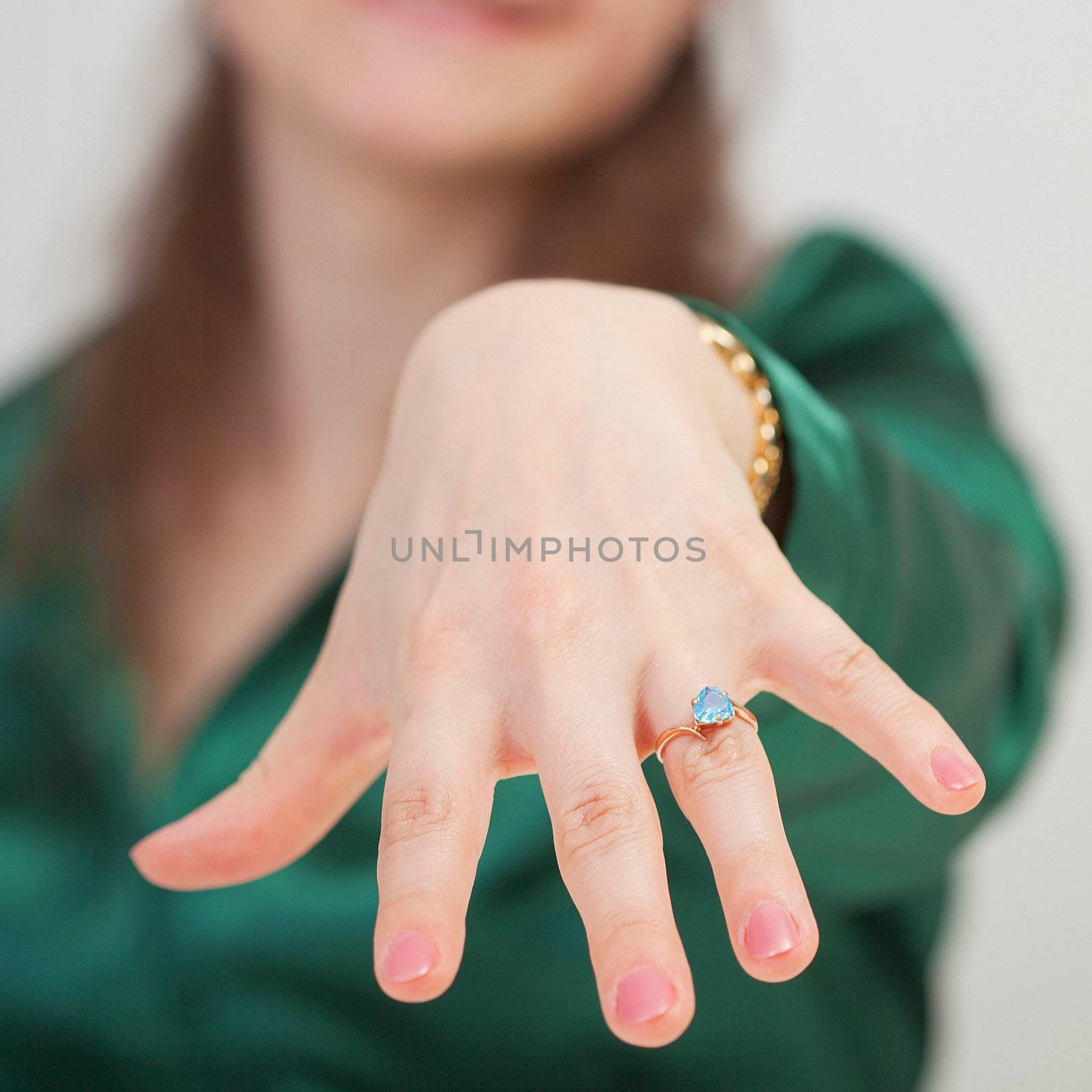 A woman shows off her new ring with blue gem