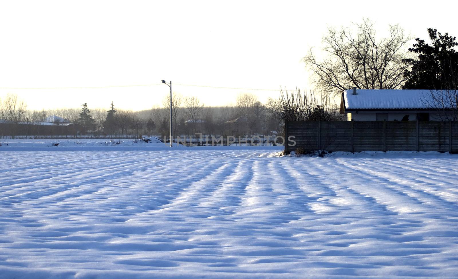 Landscape full of snow with lights of sunset on the background