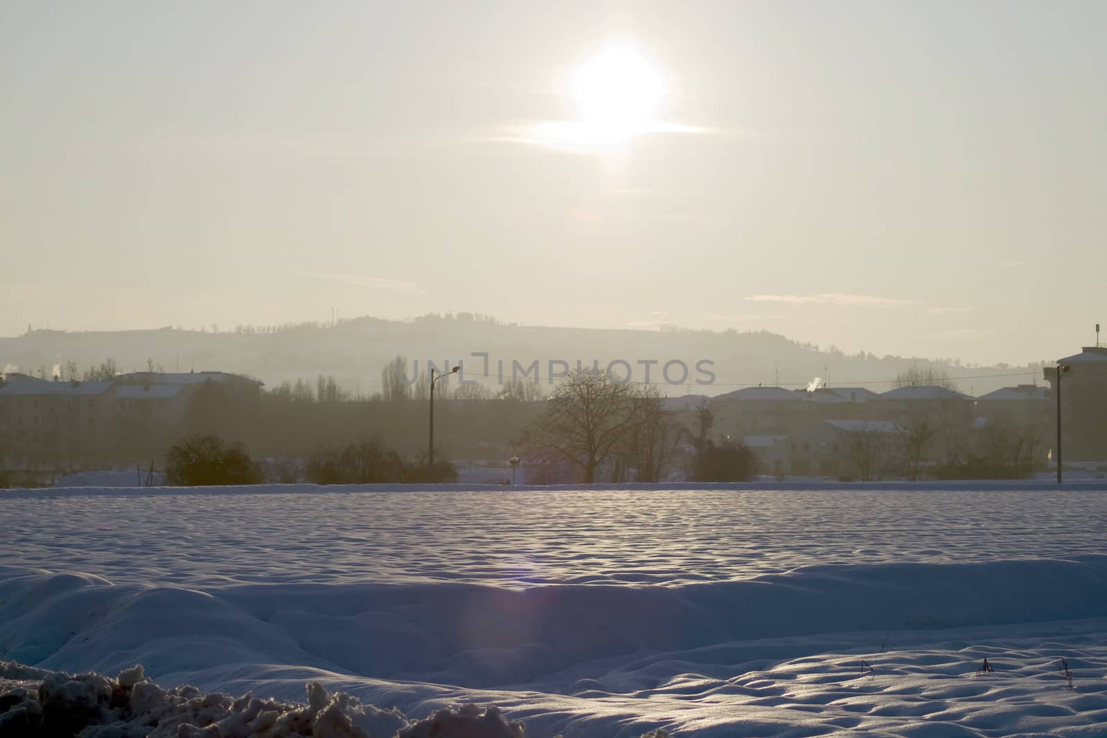 Landscape of country under the snow, with great sun in front
