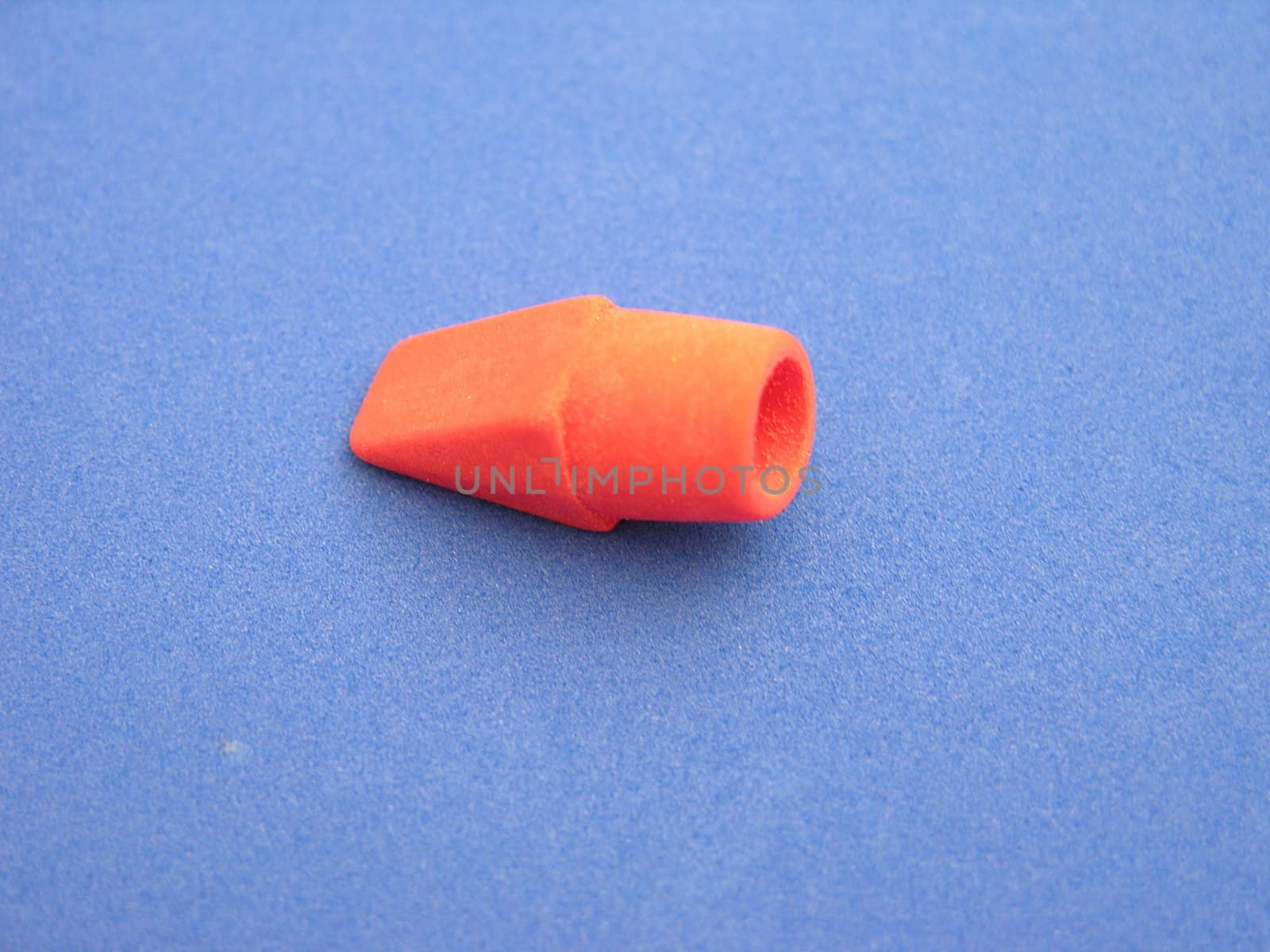 A red eraser top on a blue background