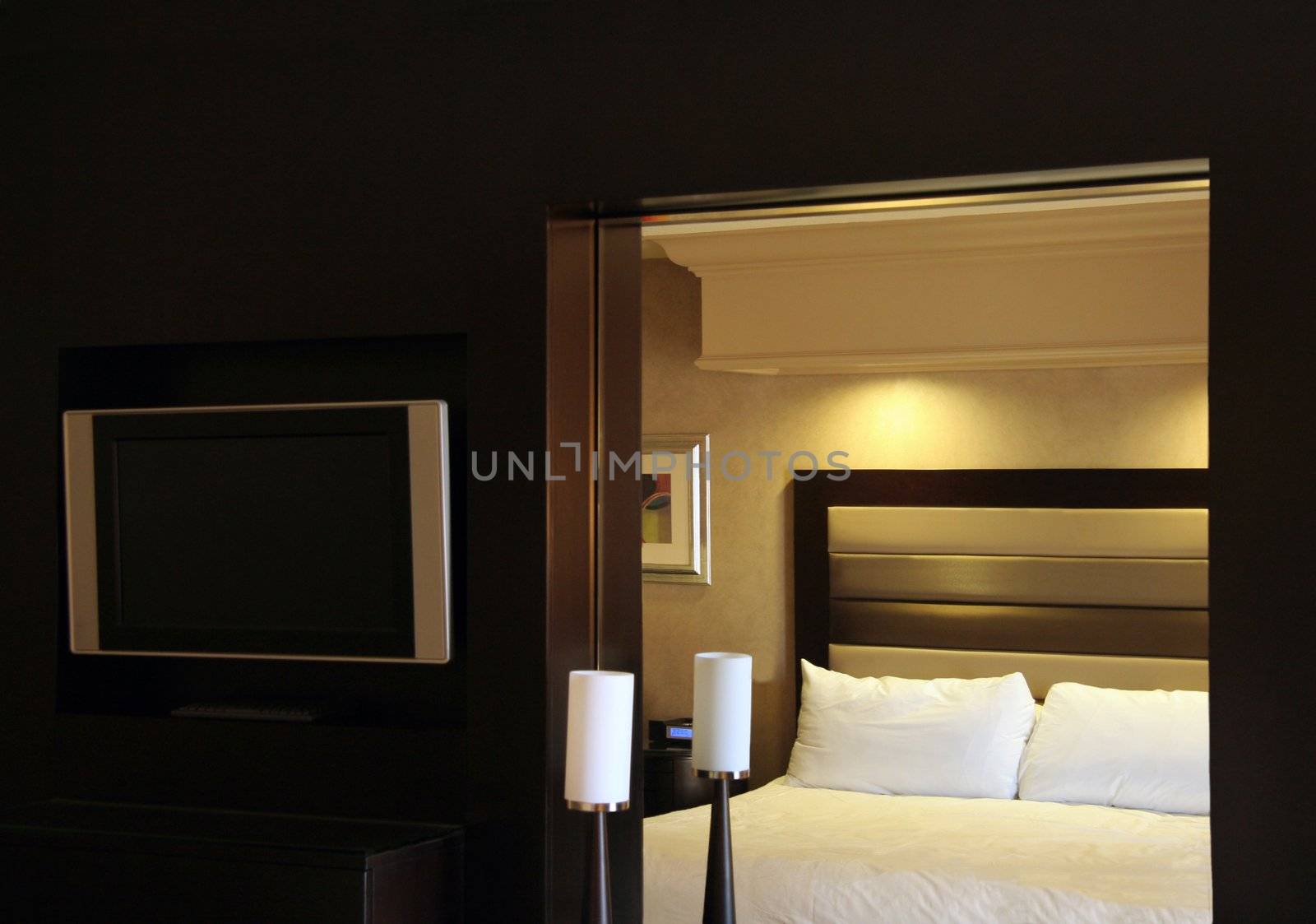 A hotel room dresser with a bed reflecting in the mirror