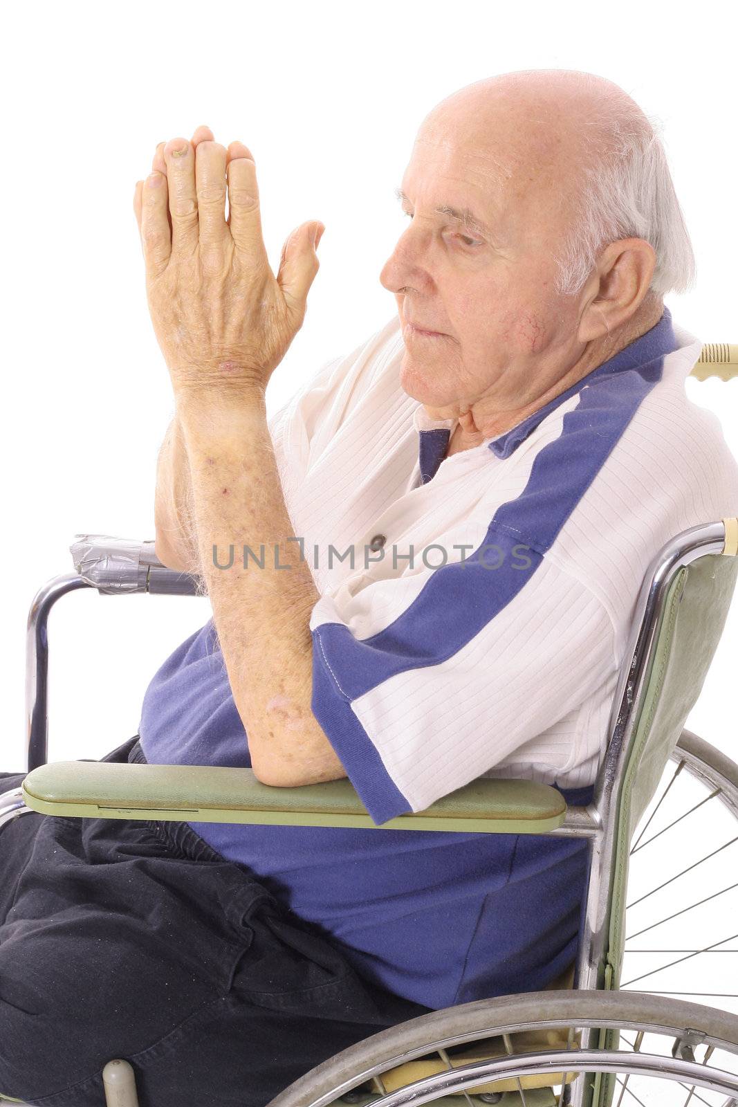 handicap senior praying in wheelchair isoalted on white by creativestock