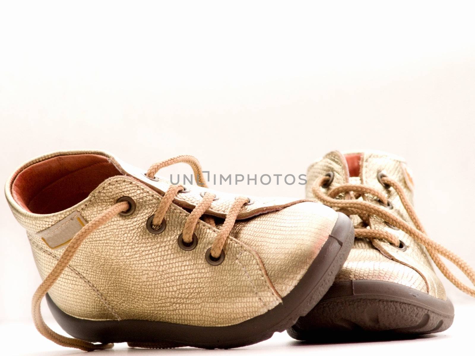 Trendy little golden baby shoes  with copy space