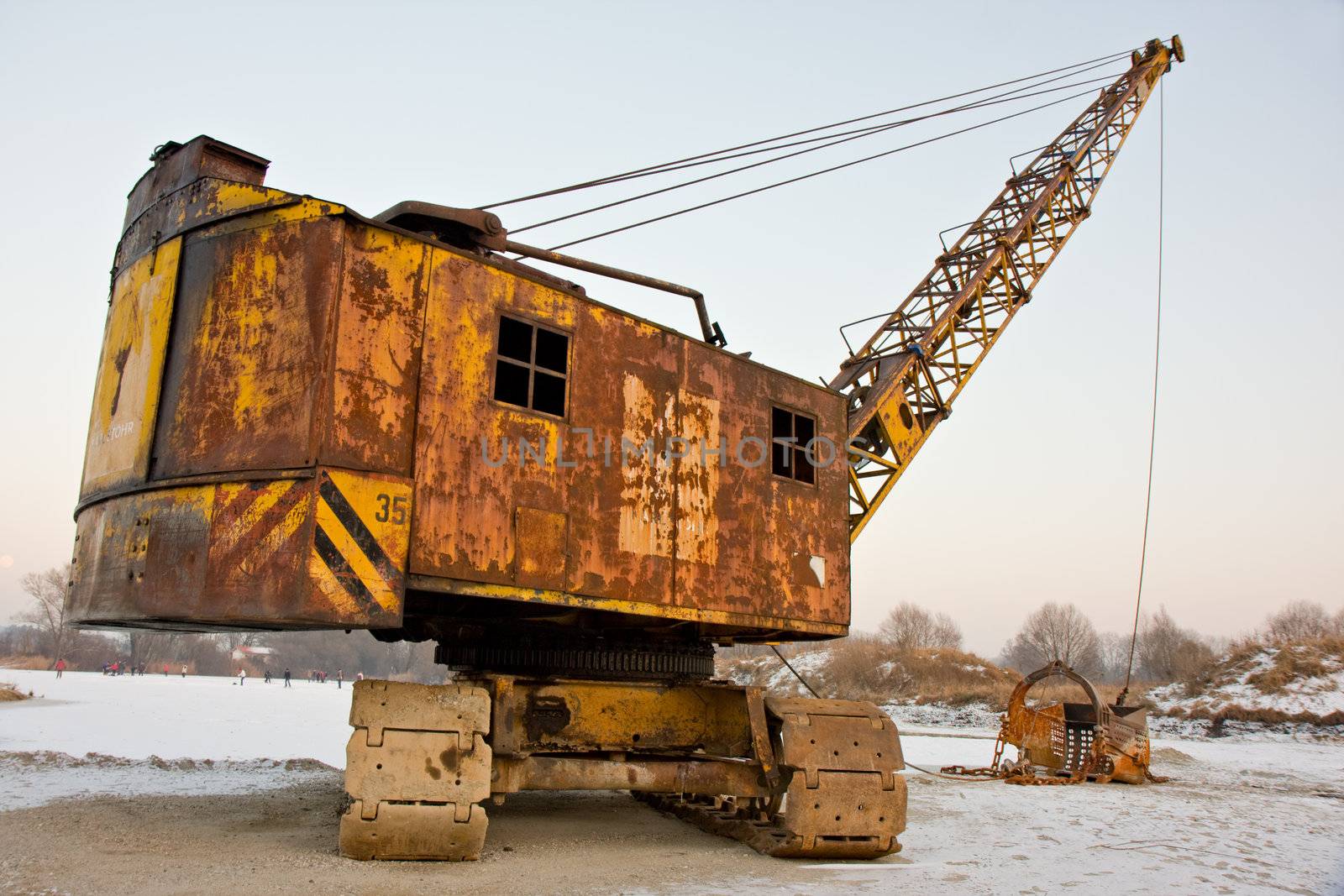 rusty old yellow excavator on a winter day by bernjuer
