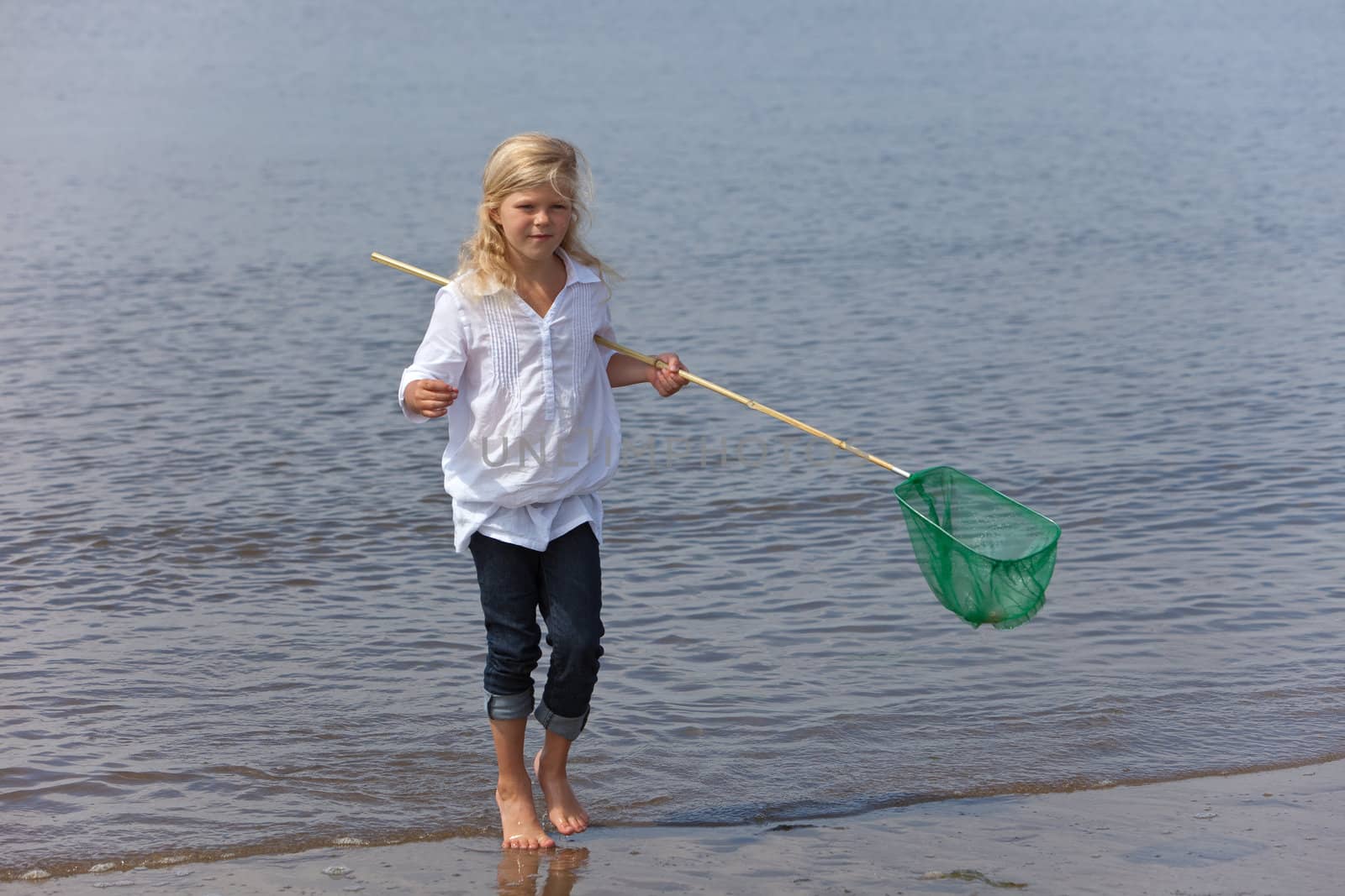Young girl by the seashore with a fishing net