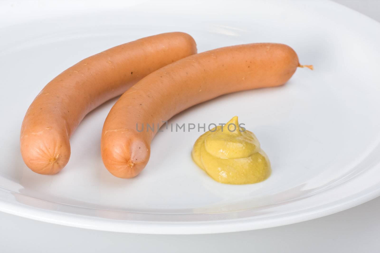 a pair of wieners on a white plate by bernjuer