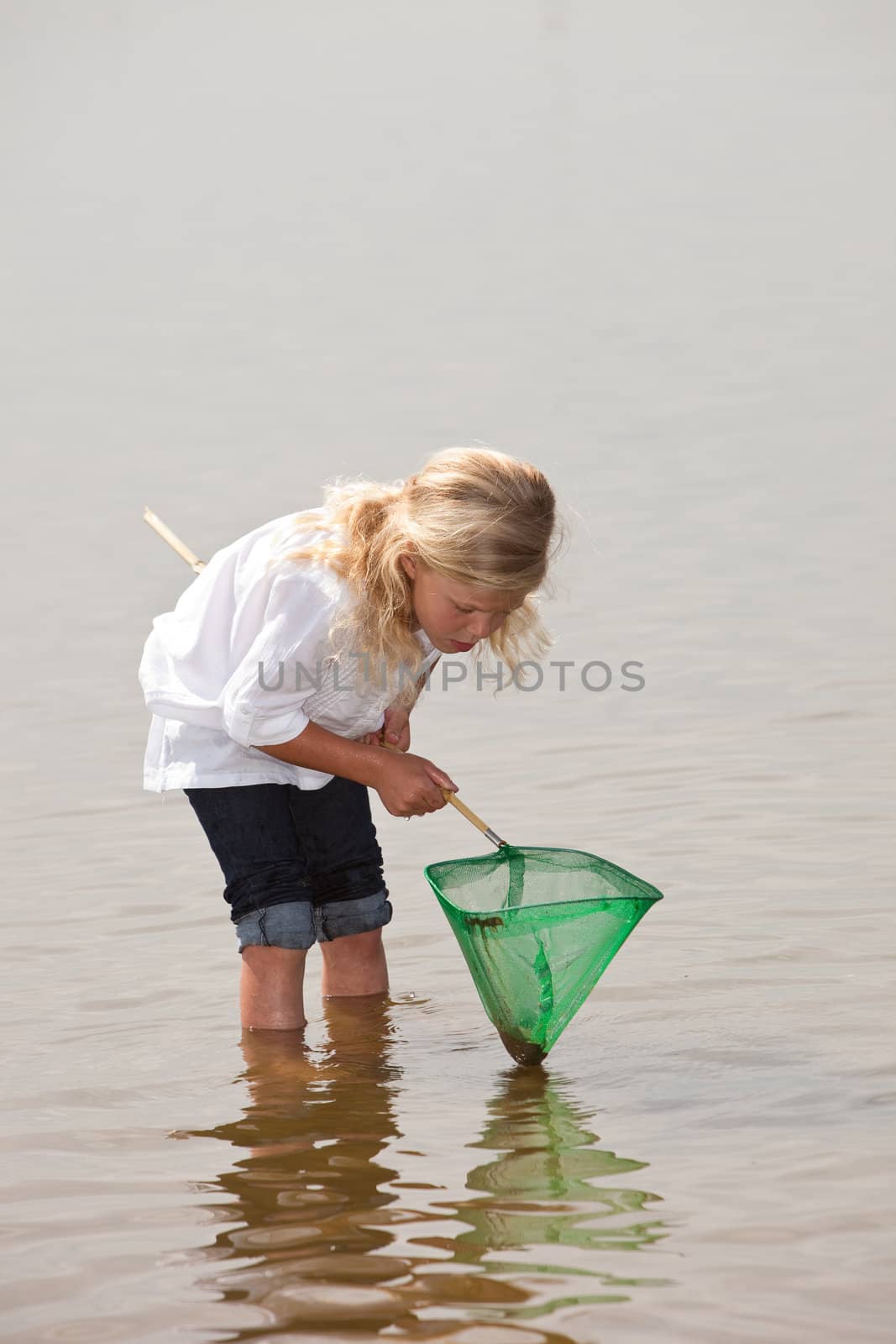 Young kid checking the content of her net to see if she has caught anything