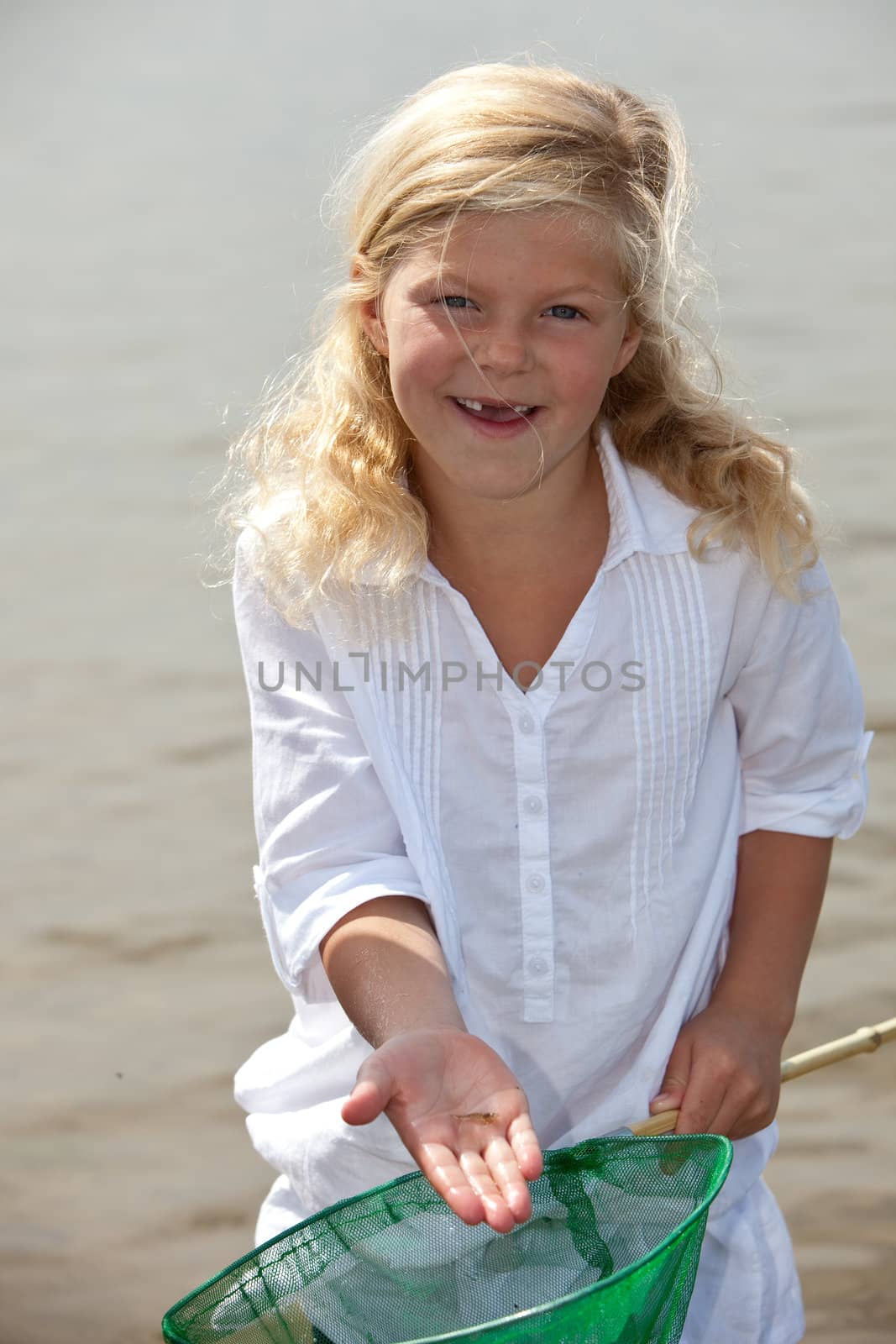 Young girl showing the shrimp she caught from the sea
