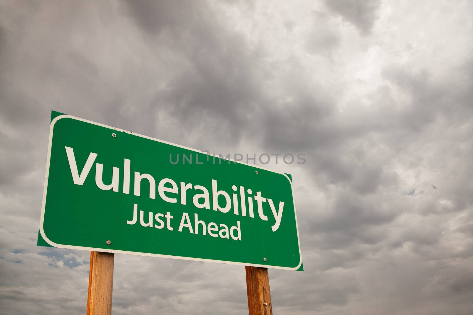 Vulnerability Just Ahead Green Road Sign with Dramatic Storm Clouds and Sky.