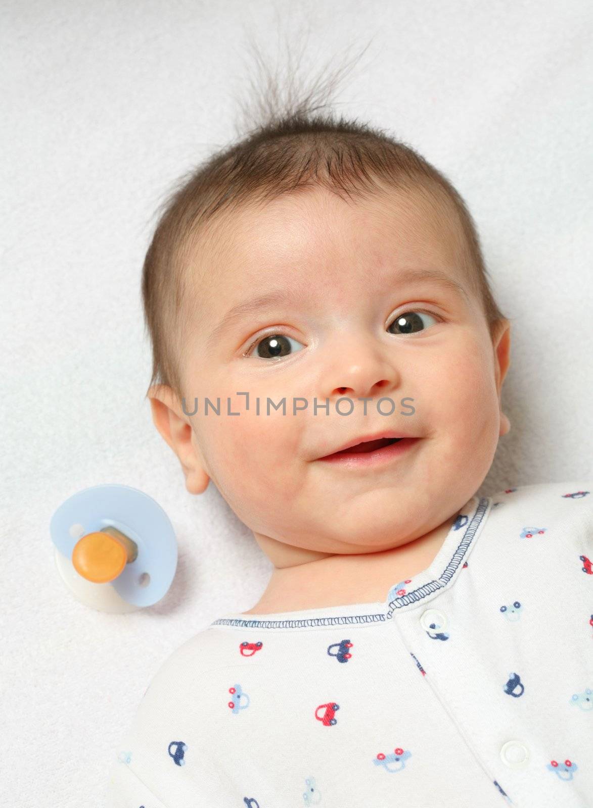 small lucky tot has spit out the baby's nipple and laughing