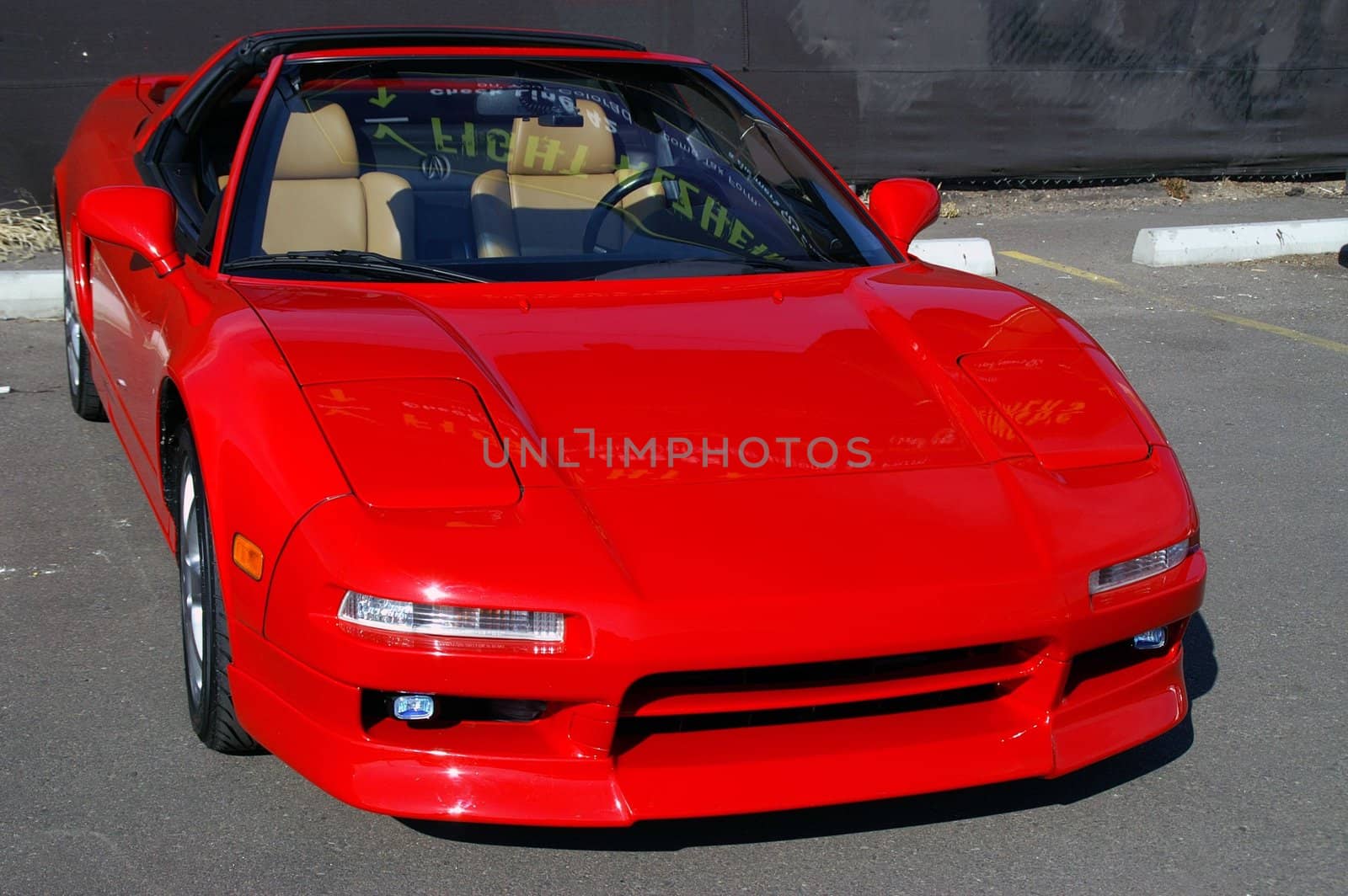 Red Acura NSX sits idle in the sunlight

