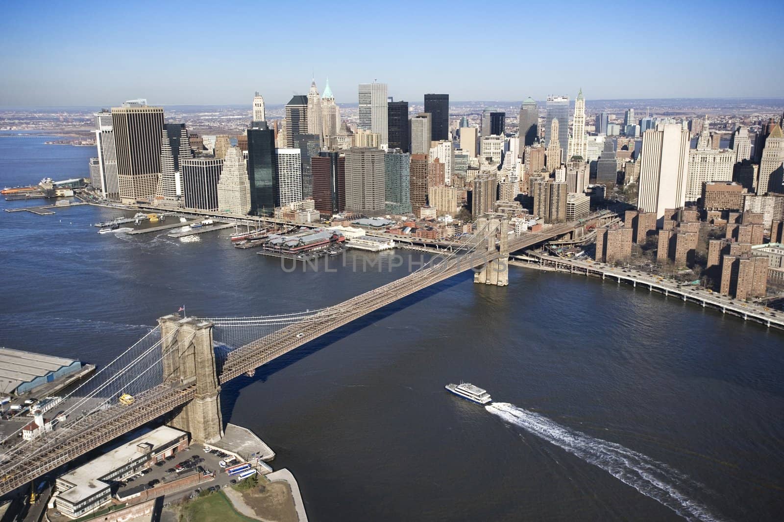 Aerial view of in New York City with Brooklyn Bridge and Manhattan skyline with ferry boat.