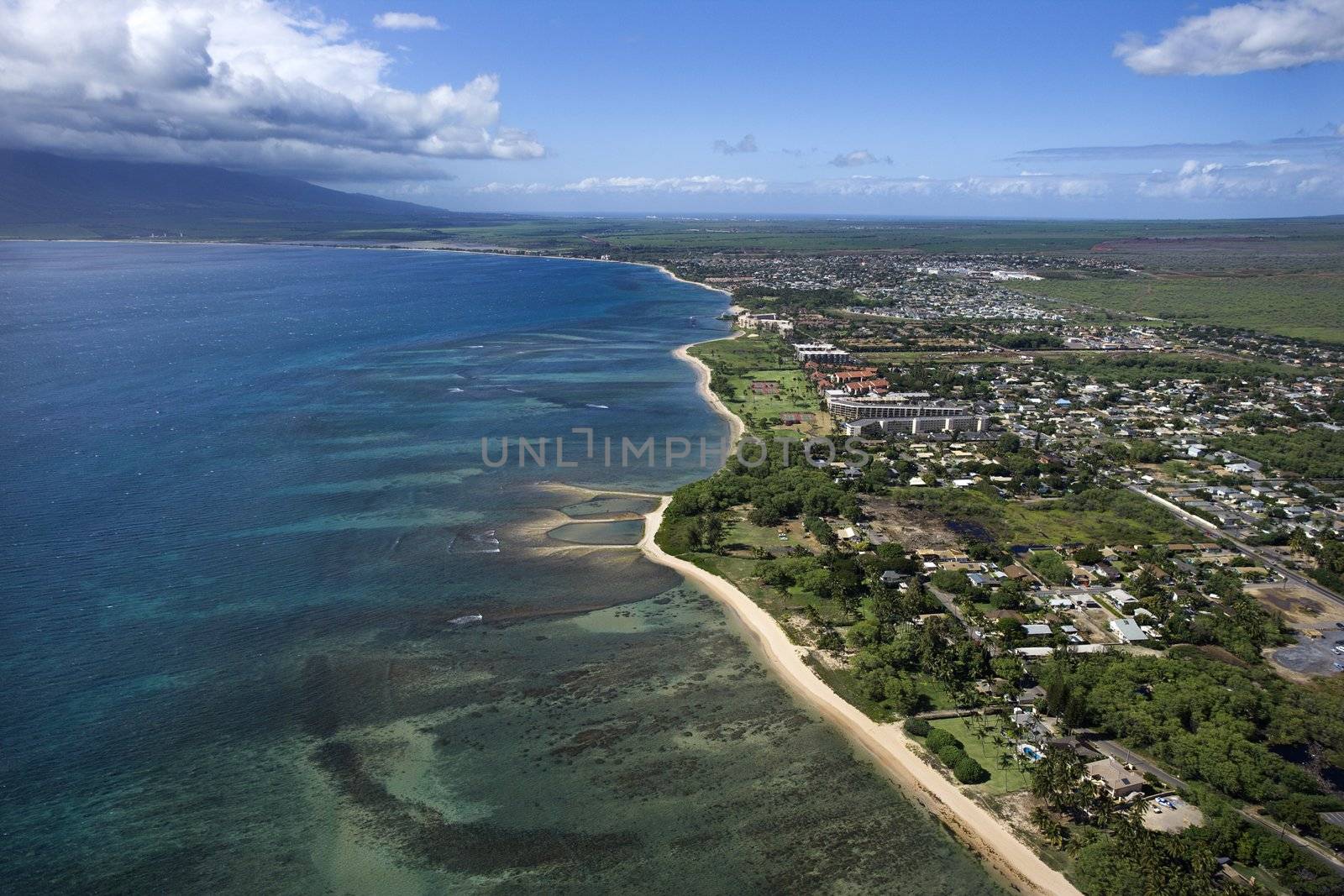 Aerial of Maui, Hawaii coastline with beach and buildings.