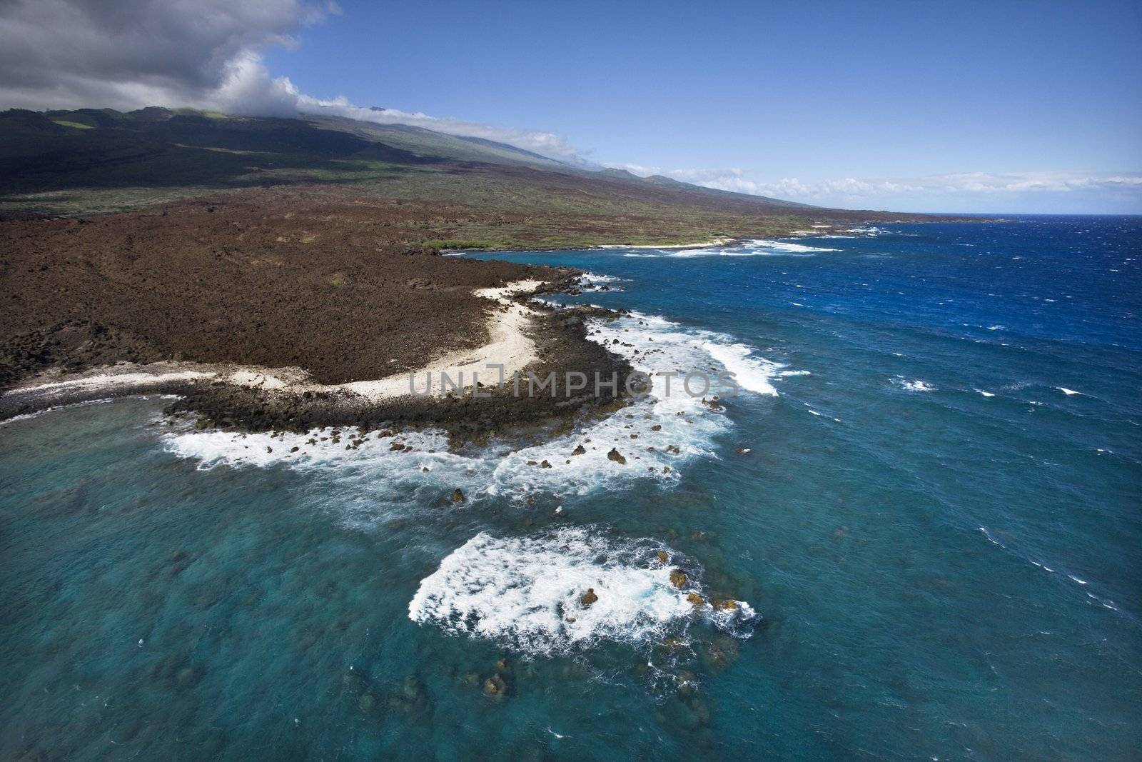 Aerial of Pacific ocean and Maui, Hawaii coast with lava rocks.