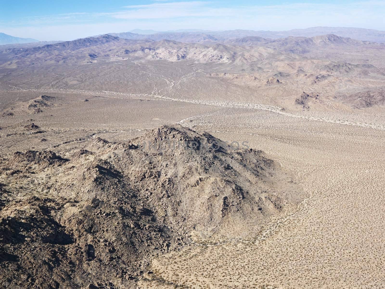 Aerial view of remote California desert with mountain range in background.