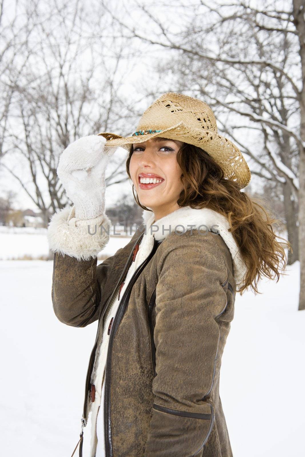 Woman tilting hat. by iofoto