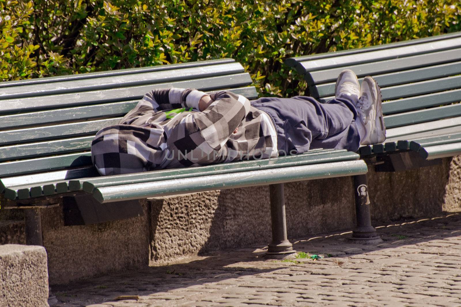  The man sleeps on a bench in city park