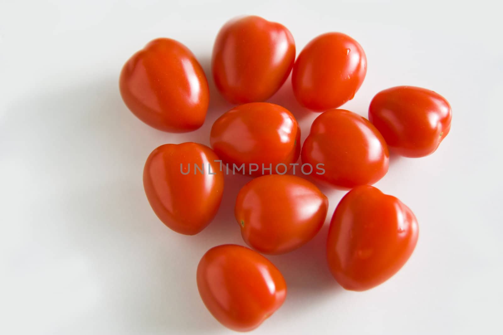 Ten ripe tomatoes on a white background