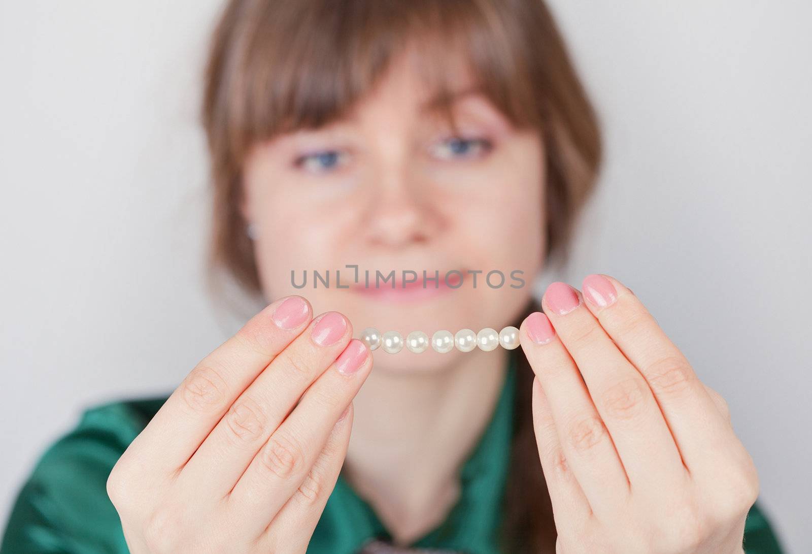 Young girl admires a beads from pearls by pzaxe