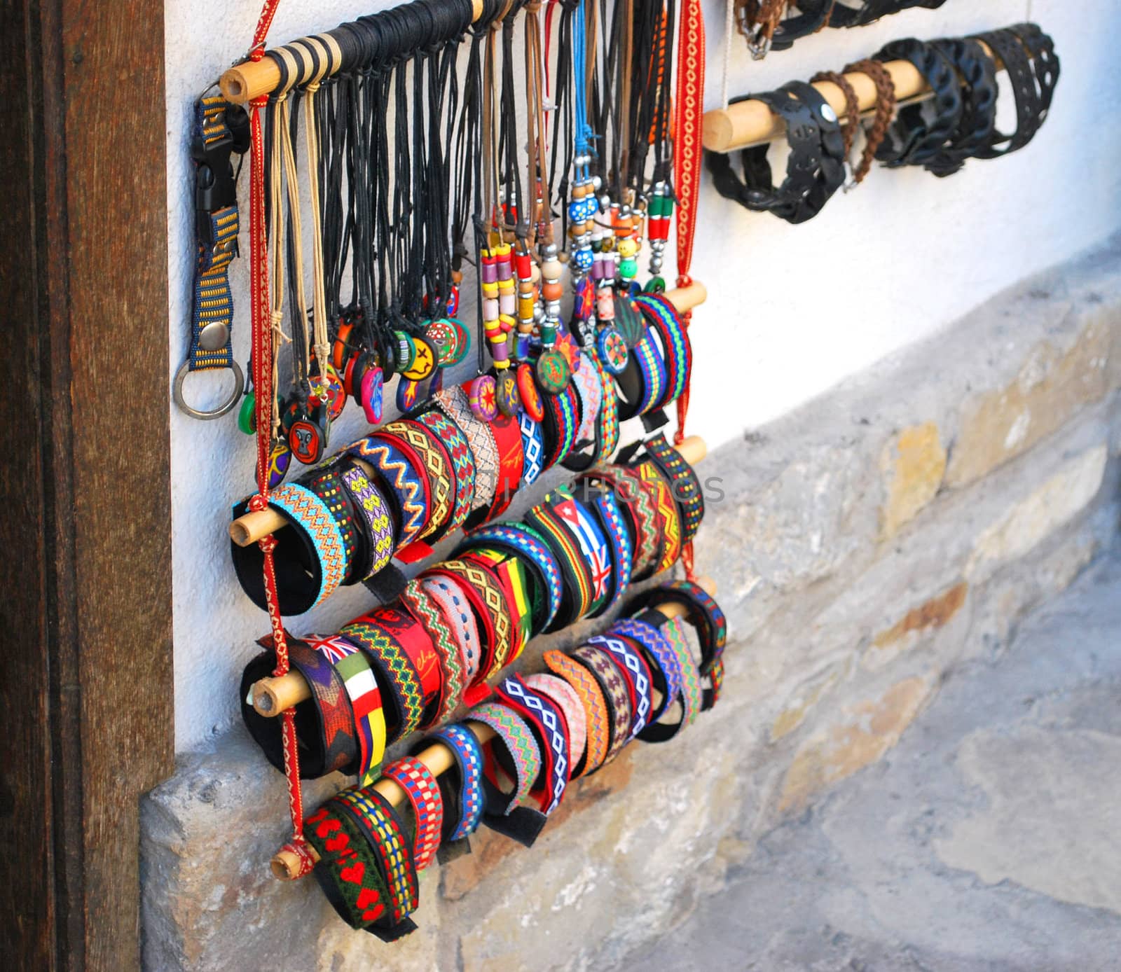 row of colorful bracelets and necklaces with different types of stones and woods