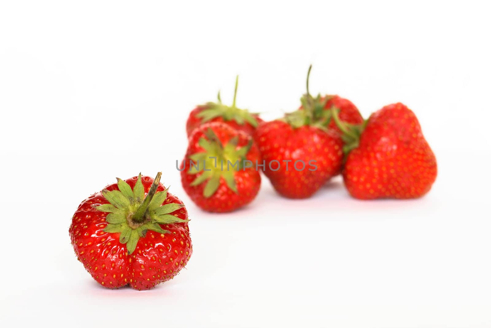 Few red freshness strawberries lying on white background