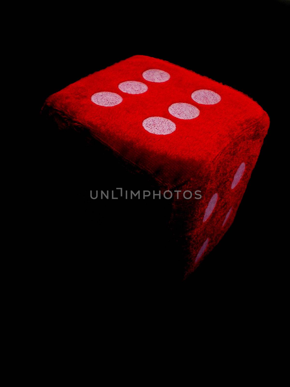 one red die isolated on black background