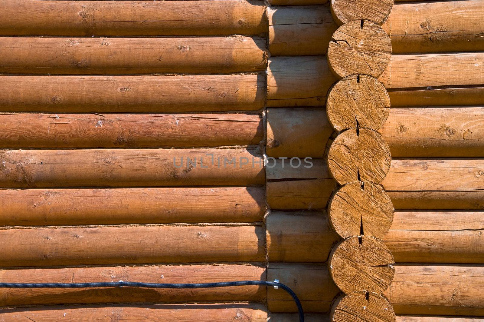 Detail of the wall section log house. Close-up. Stained wood and smooth sawn timber. Pine