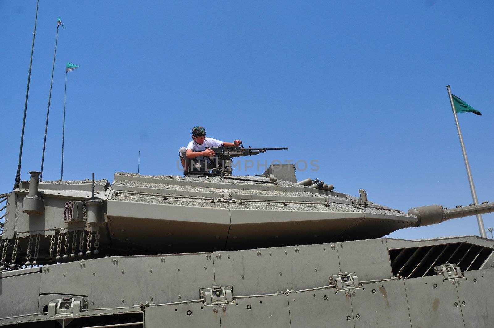 A boy playing with a machine gun mounted on top of the turret.