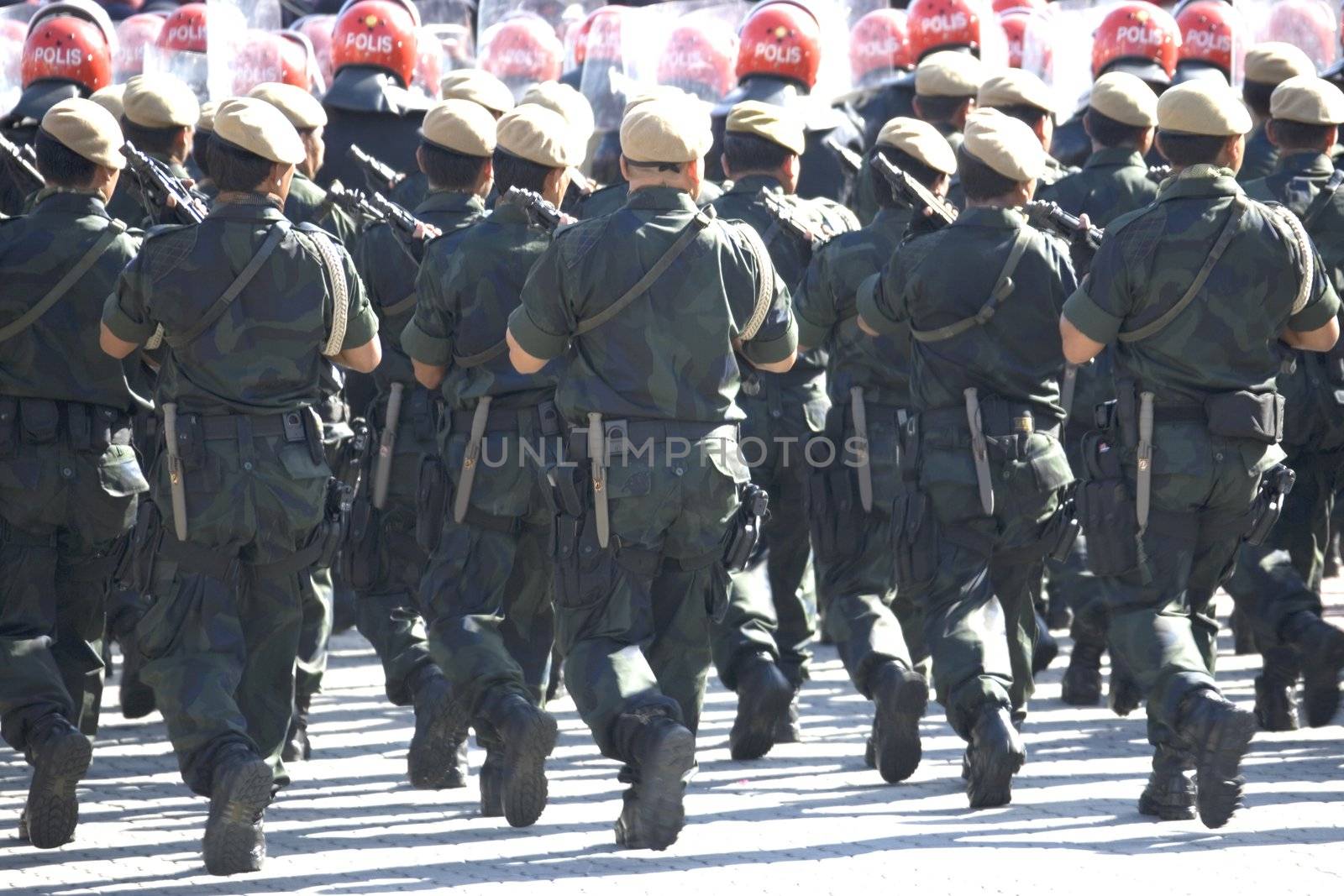 Image of armed uniformed police marching.