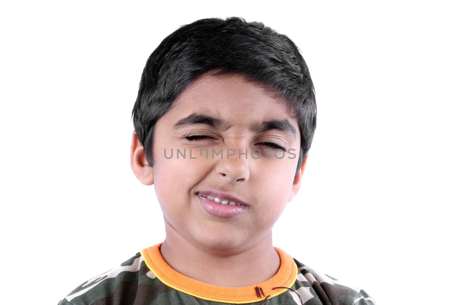 A cute little Indian boy trying to wink, on white studio background.