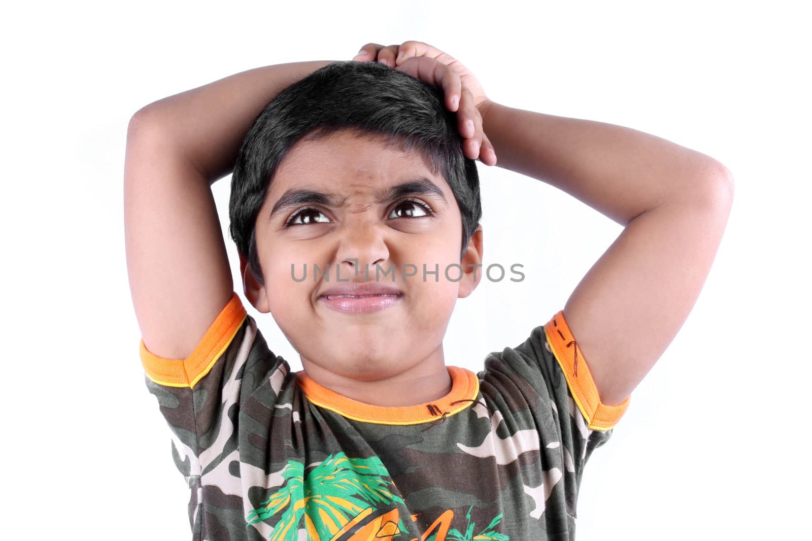 A metaphorical portrait of a cute Indian boy expressing his dislike about something, on white studio background.